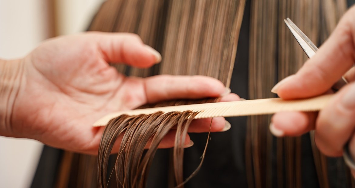 Cabeleireiro profissional adaptando o corte wolf cut feminino ao tipo de rosto da cliente.